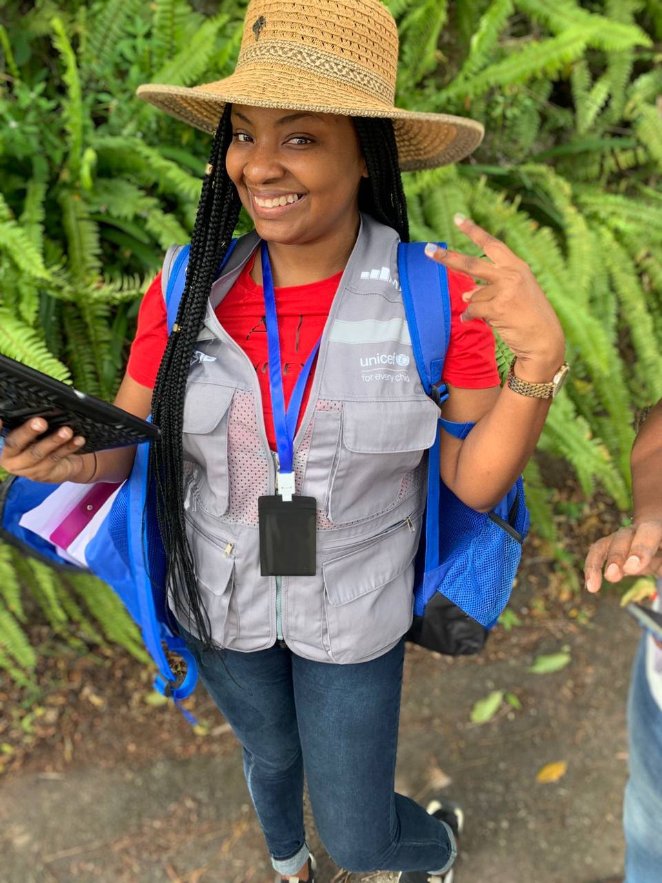 A Balcostics interviewer in a straw hat and field vest holding a tablet